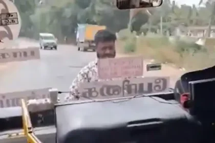 அரசு பேருந்து முன்புறம் தொங்கியபடி பயணி ஒருவர் செல்லும் காட்சி