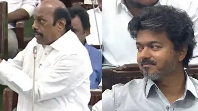 முன்னாள் அமைச்சர் எ.வ.வேலு சைகையில் பேசுகிறார், அவரை முதலமைச்சர் விஜய் புன்னகையுடன் கவனிக்கிறார்.