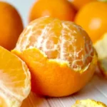 கர்ப்பிணிப் பெண் ஆரஞ்சு பழத்தை கையில் வைத்திருக்கும் காட்சி
