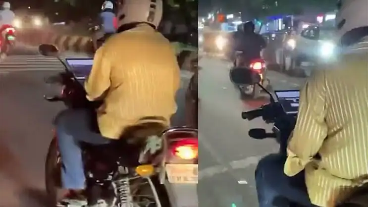 இருசக்கர வாகனத்தில் லேப்டாப்பை பயன்படுத்தும் இளைஞர்