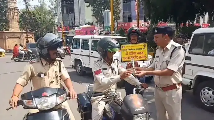 இரு சக்கர வாகனத்தில் ஹெல்மெட் அணிந்து செல்லும் போலீஸ் அதிகாரி