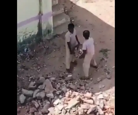 பள்ளி வளாகத்தில் கற்களை அள்ளும் மாணவர்கள்