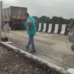 சாலையை உலர்த்த டேபிள் ஃபேன் வைக்கப்பட்டிருக்கும் காட்சி