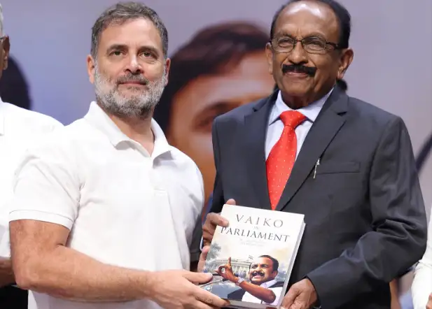 புத்தகத்தை பெற்றுக்கொள்ளும் ராகுல் காந்தி, அருகில் வைகோ