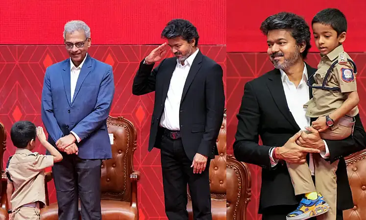 முதலமைச்சர் விஜய் சிறுவனை கையில் ஏந்தியபடி புகைப்படம் எடுக்கிறார்