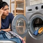 வாஷிங் மெஷினில் துணிகளைப் பிரித்து போடும் பெண்